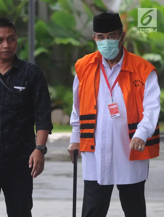 Bupati Bandung Barat Abubakar mengenakan masker dan tongkat berjalan saat tiba di gedung KPK, Jakarta, Selasa (24/4). Abubakar diperiksa perdana pasca penahanan oleh KPK. (Merdeka.com/Dwi Narwoko)
