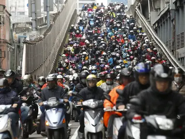 Pengendara sepeda motor memenuhi sebuah jembatan pada jam sibuk pagi hari di Taipei, Taiwan, Senin (14/3/2016). Di Taipei, orang lebih banyak memilih naik motor untuk mengejar waktu atau bisa dengan mudah mampir ke beberapa tempat. (REUTERS/Tyrone Siu)