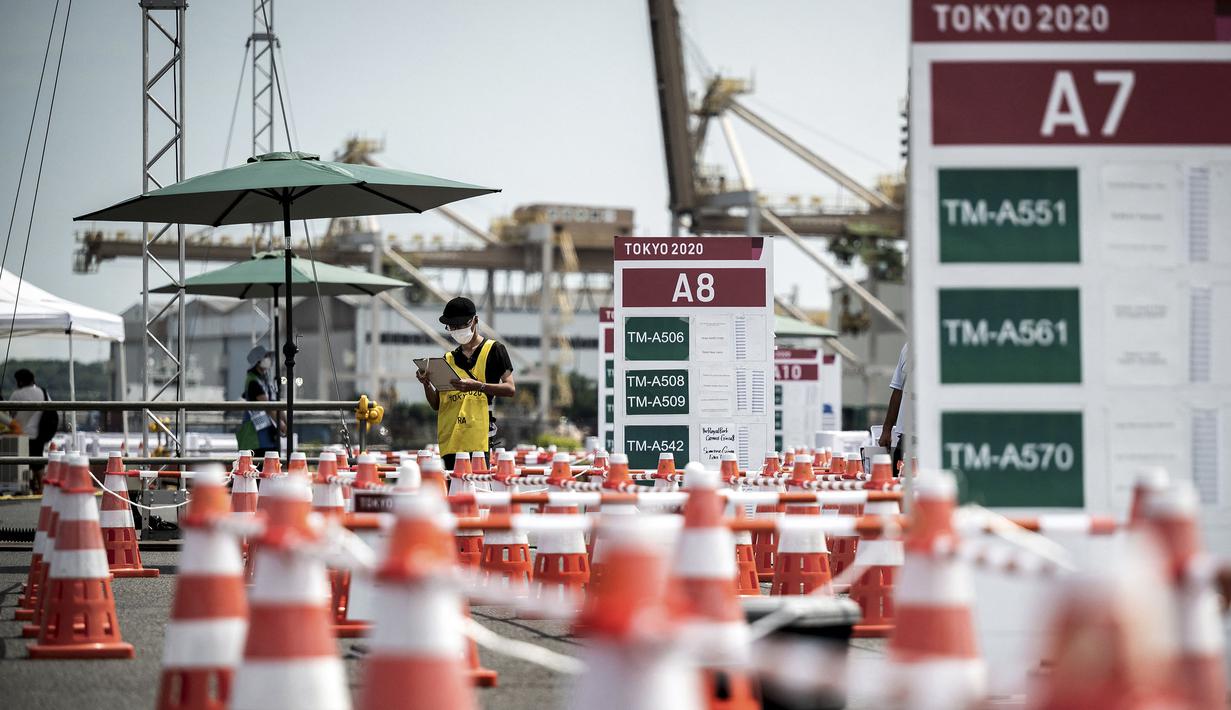 Seorang relawan menunggu di terminal bus pada 20 Juli 2021 di Tokyo, tiga hari sebelum upacara pembukaan Olimpiade Tokyo 2020. (AFP/Jeff Pachoud)