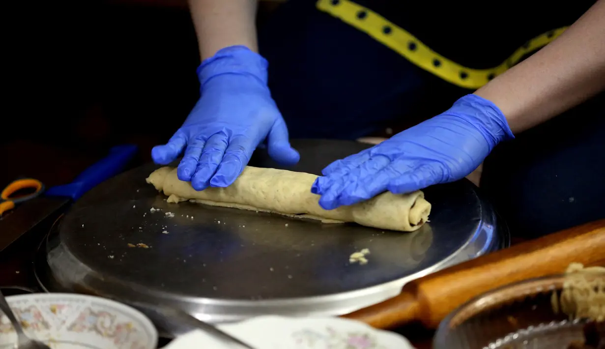 Seorang warga Irak membuat kue tradisional yang dikenal sebagai Kleicha untuk perayaan Idul Fitri di Baghdad, Irak, pada 23 Mei 2020. Kleicha, kue populer yang terbuat dari tepung dan mentega di Irak, dikreasikan dalam berbagai bentuk dengan beragam isian. (Xinhua/Khalil Dawood)