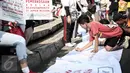 Seorang warga menandatangi spanduk aksi solidaritas untuk Yuyun disela kegiatan car free day di Bundaran HI, Jakarta, Minggu (8/5). Aksi solidaritas tersebut pun berlangsung serentak di 13 kota lainnya. (Liputan6.com/Faizal Fanani)