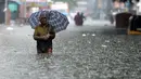 Orang-orang mengarungi jalan yang banjir setelah hujan lebat di Chennai, India (8/11/2021). Hujan lebat terus menyebabkan genangan air di Chennai dan daerah sekitarnya. (AFP/Arun Sankar)