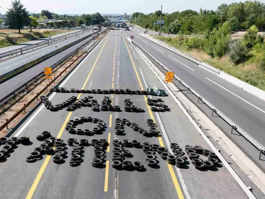 Ratusan ban dijejerkan membentuk tulisan " Valls, we're waiting for you", yang ditujukan untuk Perdana Menteri Perancis, Manuel Valls di Jalan raya A6 Limonest, Lyon, Prancis, (23/7/2015). (REUTERS/Robert Pratta)