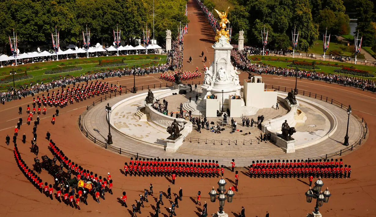 Warga menyaksikan prosesi pemindahan peti jenazah Ratu Elizabeth II dari Istana Buckingham ke Westminster Hall di London, Inggris, 14 September 2022. Pangeran William dan Pangeran Harry juga mengikuti dari belakang. (Chip Somodevilla/Pool via AP)