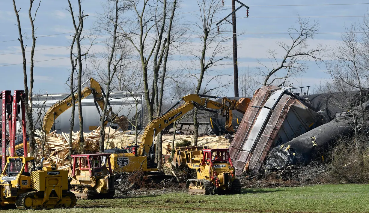Petugas memindahakan puing-puing dari kecelakaan kereta barang di Georgetown, Kentucky, Amerika Serikat, Senin (19/3). Kecelakaan ini mengakibatkan kebakaran. (AP Photo/Timothy D. Easley)
