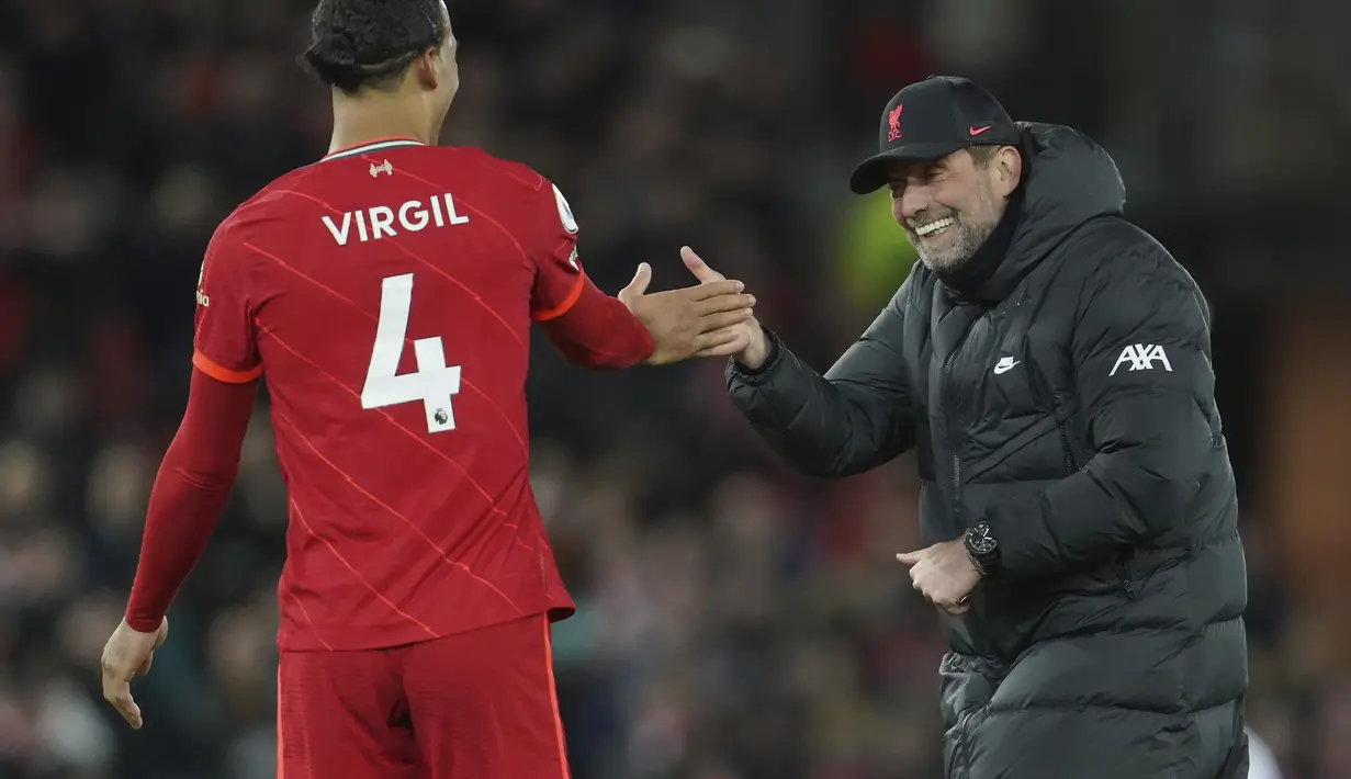 Pelatih Liverpool Jurgen Klopp merayakan kemenangan dengan bek Virgil van Dijk usai mengalahkan Leeds United pada pertandingan lanjutan Liga Inggris di stadion Anfield di Liverpool, Inggris, Kamis (24/2/2022). Liverpool menang telak atas Leeds United 6-0.  (AP Photo/Jon Super)