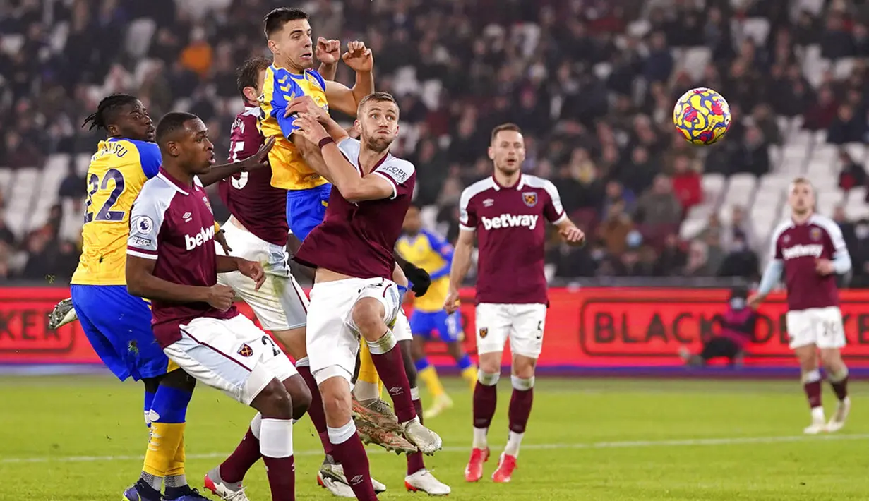 Pemain Southampton Jan Bednarek (atas) mencetak gol ke gawang West Ham United pada pertandingan sepak bola Liga Inggris di London Stadium, London, Minggu (26/12/2021). Southampton menang 3-2. (Adam Davy/PA via AP)