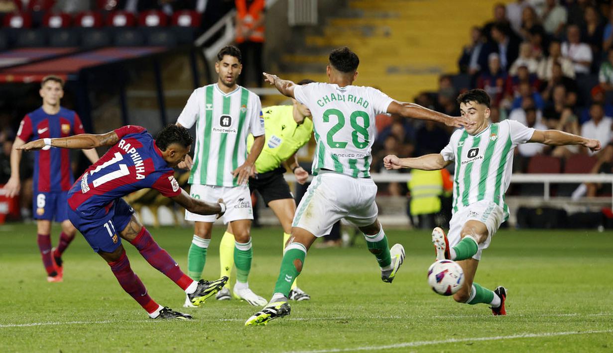 Pemain Barcelona, Raphinha, mencetak gol ke gawang Real Betis pada laga Liga Spanyol di Estadi Olimpic Lluis Companys, Minggu (17/9/2023). Gol-gol Barcelona disumbangkang oleh Joao Felix, Robert Lewandowski, Ferran Torres, Raphinha dan Joao Cancelo. (AP Photo/Joan Monfort)