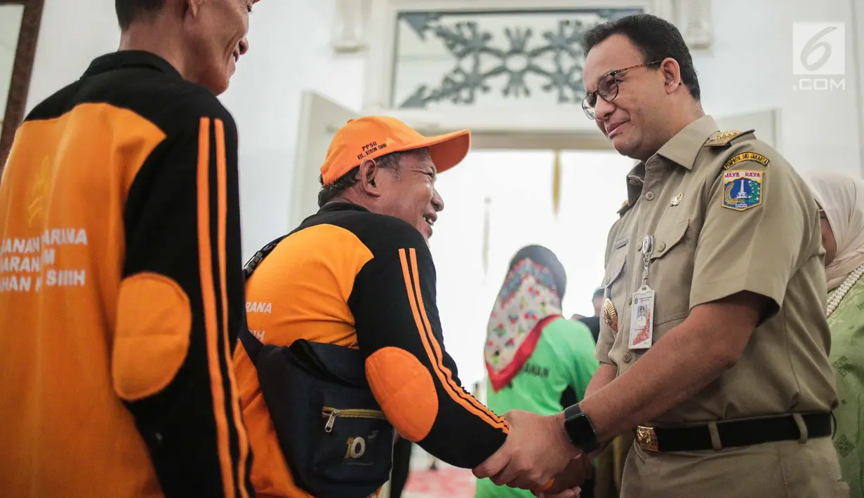 Gubernur DKI Jakarta Anies Baswedan bersalaman dengan pasukan oranye saat menggelar halal bihalal di Balaikota, Jakarta, Senin (10/6/2019). Pemerintah Provinsi DKI Jakarta menggelar Halal Bihalal pada hari pertama PNS masuk kerja setelah libur Lebaran 2019. (Liputan6.com/Faizal Fanani)