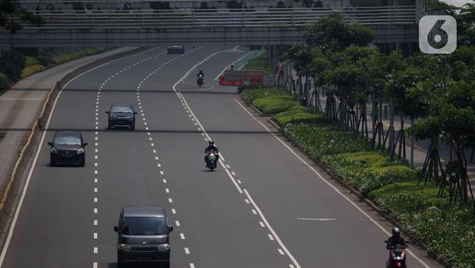Sejumlah kendaraan melintas di ruas jalan protokol di Jakarta, Jumat (10/4/2020). Pemerintah resmi memberlakukan PSBB setelah adanya Peraturan Pemerintah (PP) Nomor 21 Tahun 2020 dengan didukung oleh Peraturan Menteri Kesehatan (PMK) Nomor 9 Tahun 2020. (Liputan6.com/Angga Yuniar)