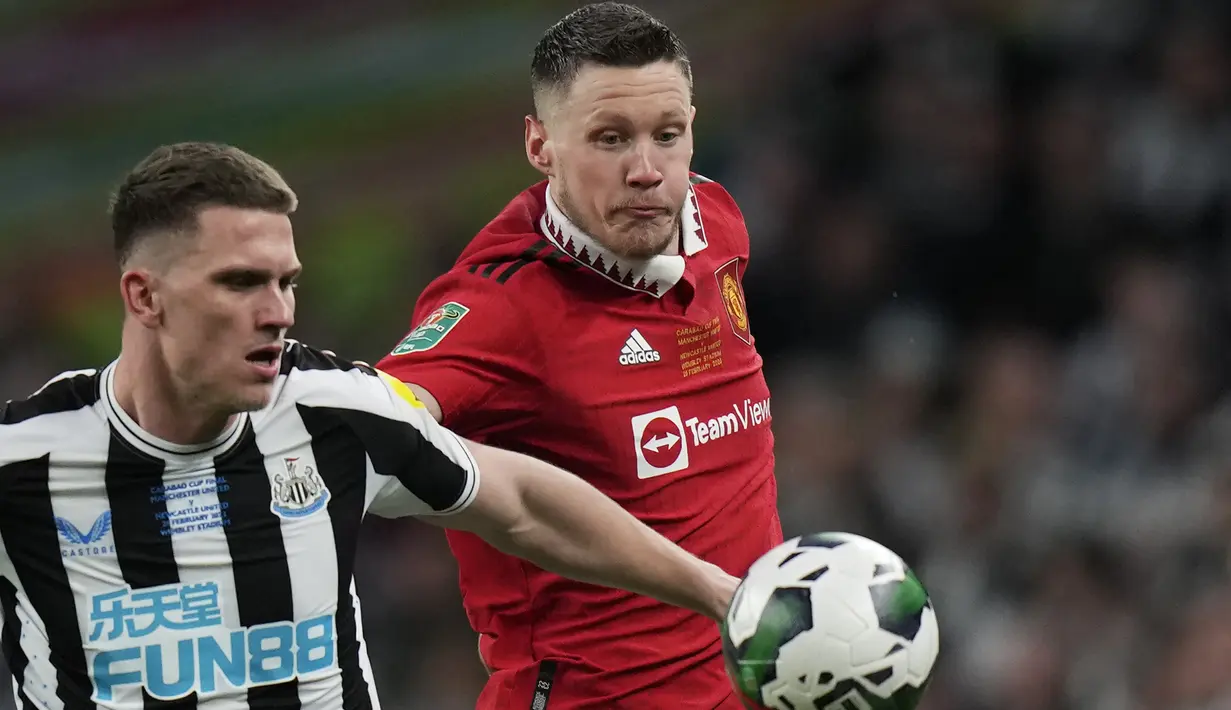 Penyerang Manchester United (MU)  Wout Weghorst berebut bola dengan bek Newcastle United Sven Botman pada partai final Carabao Cup 2022/2023 di Stadion Wembley, Senin dini hari WIB (27/2/2023). MU tampil tangguh untuk membekuk Newcastle dengan skor meyakinkan 2-0 dan menjadi juara Carabao Cup 2022-2023. (AP Photo/Scott Heppell)