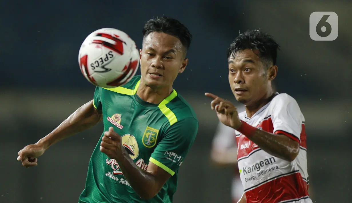 Pemain Persebaya Surabaya, Koko Ari (kiri), berebut bola dengan pemain Madura United, Mochamad Kevy, pada laga Piala Menpora 2021 di Stadion Si Jalak Harupat, Bandung, Minggu (28/3/2021). Persebaya Surabaya menang 2-1. (Bola.com/M Iqbal Ichsan)