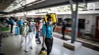 Seorang porter membawa barang penumpang kereta api Dharmawangsa dari Surabaya tiba di Stasiun Pasar Senen, Jakarta, Kamis (5/5/2022). Sebanyak 38.400 penumpang yang berangkat dari seluruh stasiun KA Jarak Jauh tiba di area Daop 1 Jakarta pada H+3 lebaran. (Liputan6.com/Faizal Fanani)
