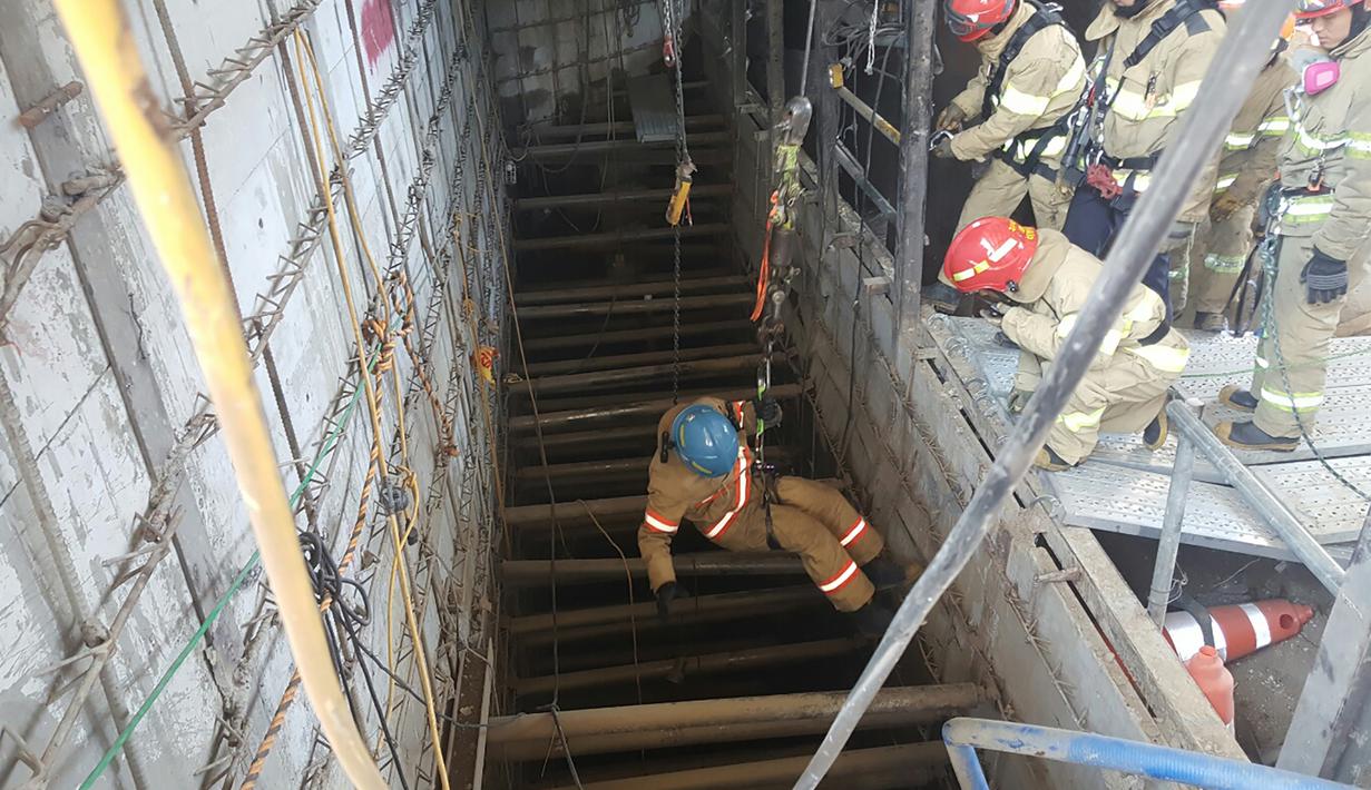 Petugas penyelamat dengan menggunakan tali turun ke lokasi robohnya konstruksi kereta bawah tanah di kota Namyangju, dekat Seoul, Korsel, Rabu (1/6). Empat pekerja tewas dan 10 orang lainnya luka-luka dalam insiden ini. (NAMYANGJU FIRE STATION/AFP)