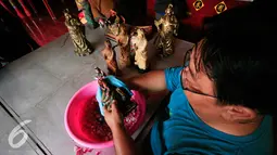 Warga keturunan Tionghoa mencuci sejumlah patung dewa di Klenteng Poncowinatan, Yogyakarta, Selasa (2/2/2016). Patung patung dewa di bersihkan untuk menyambut perayaan imlek. (Liputan6.com/Boy Harjanto)