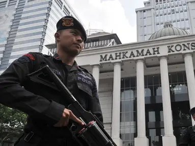 Personel kepolisian saat berjaga di depan Gedung Mahkamah Konstitusi (MK), Jakarta, Rabu (26/6/2019). Kepolisian memperketat penjagaan di sekitar Gedung MK dengan kawat berduri, kendaraan lapis baja, serta ratusan personel. (merdeka.com/Iqbal S. Nugroho)