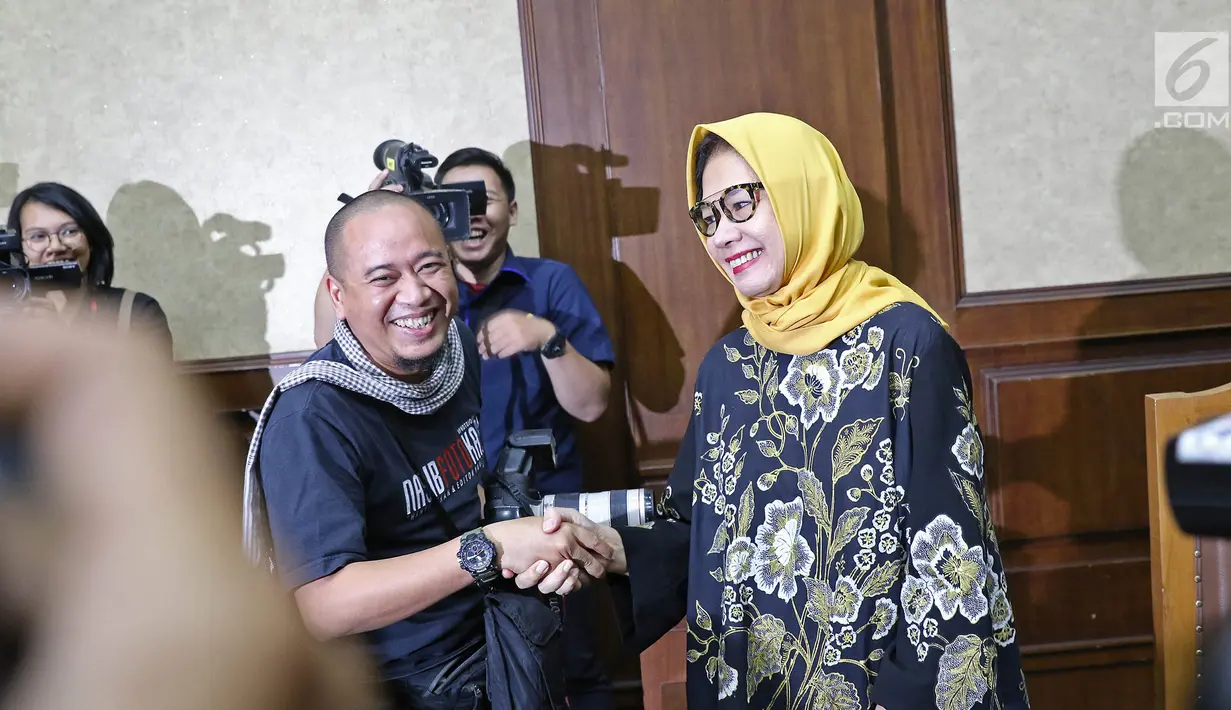 Terdakwa kasus dugaan korupsi investasi perusahaan di blok Basker Manta Gummy (BMG) Australia tahun 2009, Karen Agustiawan (kanan) bersalaman dengan awak media saat akan menjalani sidang pembacaan putusan di Pengadilan Tipikor, Jakarta, Senin (10/6/2019). (Liputan6.com/Herman Zakharia)