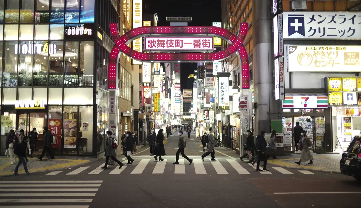 Orang-orang berjalan di sekitar lingkungan Shinjuku Tokyo, Kamis (7/1/2021). Pemerintah Jepang kembali memberlakukan status keadaan darurat Virus Corona COVID-19 untuk Tokyo, Kanagawa, Saitama, dan Chiba.  (AP Photo/Hiro Komae)