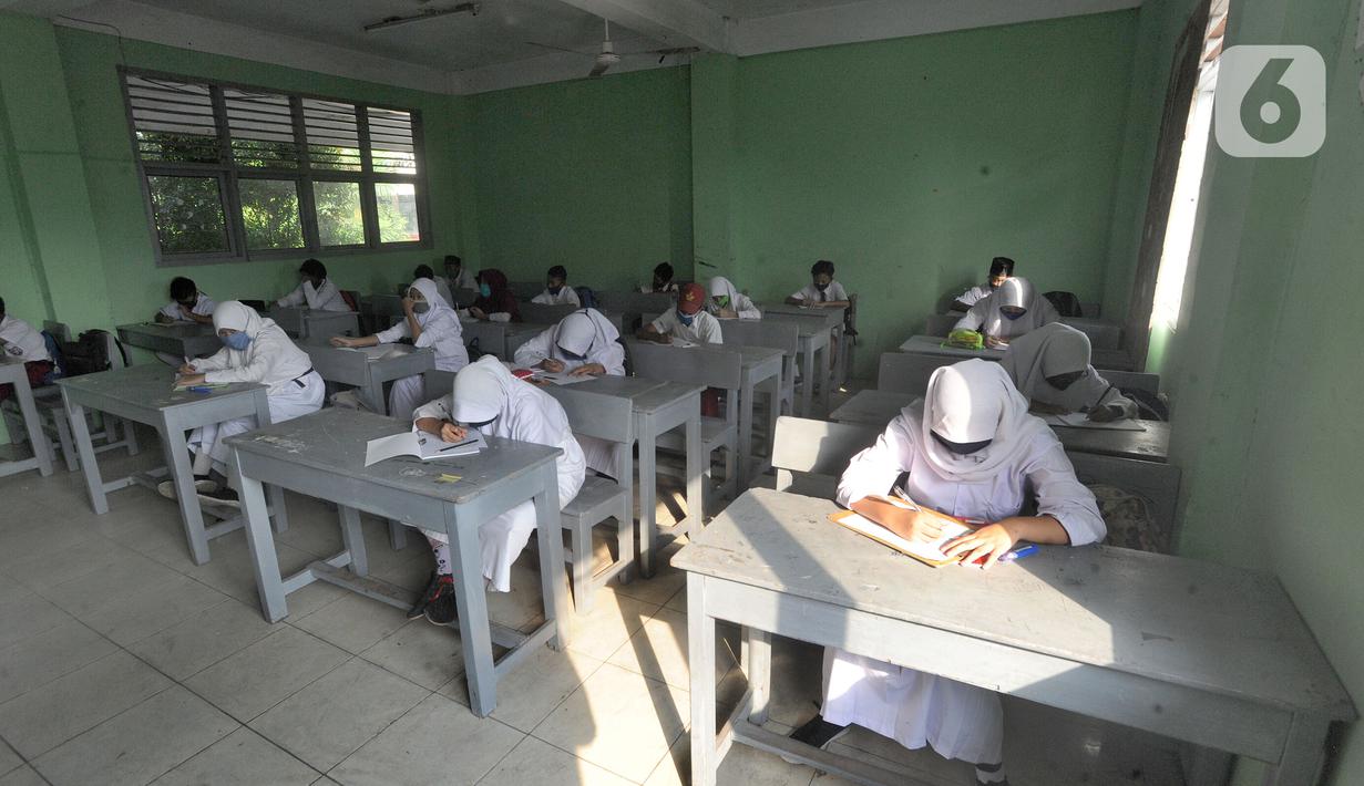 Murid baru menggunakan masker  mengikuti tes penentuan kelas tahun ajaran 2020-2021 yang selanjutnya akan mengikuti kegiatan belajar mengajar (KBM) secara darling di MTs Hidayatul Umami, Cinere, Depok, Jawa Barat, Senin (13/7/2020). (merdeka.com/Arie Basuk)