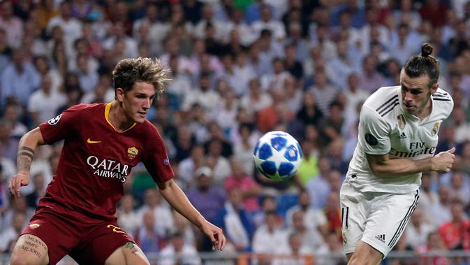 Gelandang Real Madrid, Gareth Bale (kanan) berebut bola dengan gelandang AS Roma Nicolo 'Zaniolo pada pertandingan Grup G Liga Champions di Stadion Santiago Bernabeu, Madrid, Spanyol, Rabu (19/9). Madrid membantai Roma 3-0. (AP Photo/Manu Fernandez)