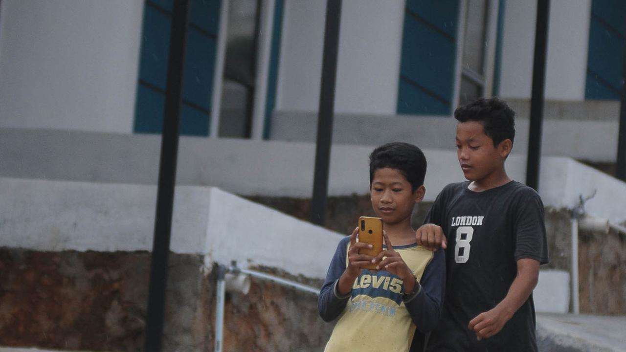 Dua orang anak saat melakukan menggunakan dompet digital dengan aplikasi Gopay di Desa Kubang, Kabupaten Bogor, Jawa Barat, Sabtu (17/2/2024). Foto: merdeka.com / Imam Buhori