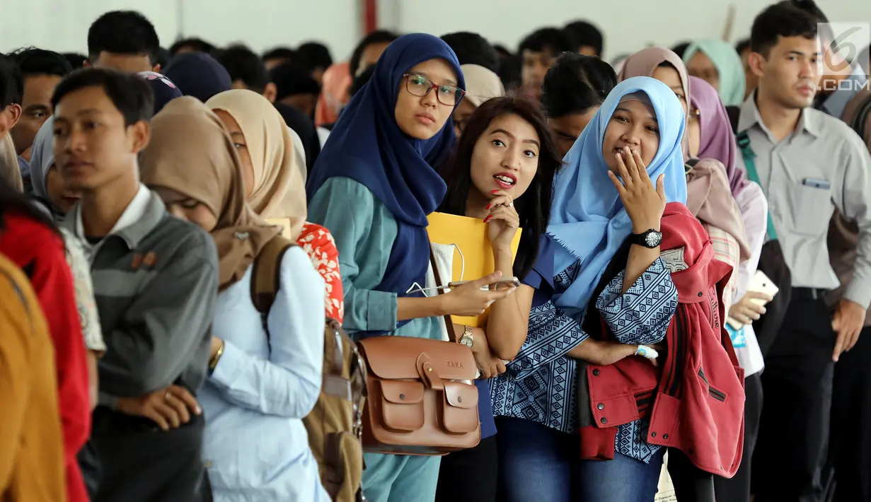Peserta mengantre untuk pendaftaran ulang ujian CPNS Kementerian Kelautan dan Perikanan (KKP) di Jakarta, Minggu (8/10). Pembukaan lowongan CPNS ini dalam rangka mengisi kekosongan 41 jabatan pada Kantor Pusat dan UPT di KKP. (Liputan6.com/Johan Tallo)