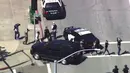 Para karyawan keluar dari gedung dengan mengangkat tangan saat insiden penembakan di kantor pusat YouTube di San Bruno, California, Selasa (3/4). Pelaku penembakan ditemukan tewas diduga menembak dirinya setelah melakukan penyerangan. (KGO-TV via AP)