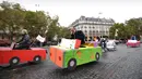 Sejumlah orang naik sepeda yang dihias kardus berbentuk mobil di Place de la Bastille, Paris, Prancis (1/10). Pemerintah Prancis mendorong warganya untuk mengurangi penggunaan kendaraan bermotor guna mengurangi polusi. (AFP Photo/Eric Feferberg)