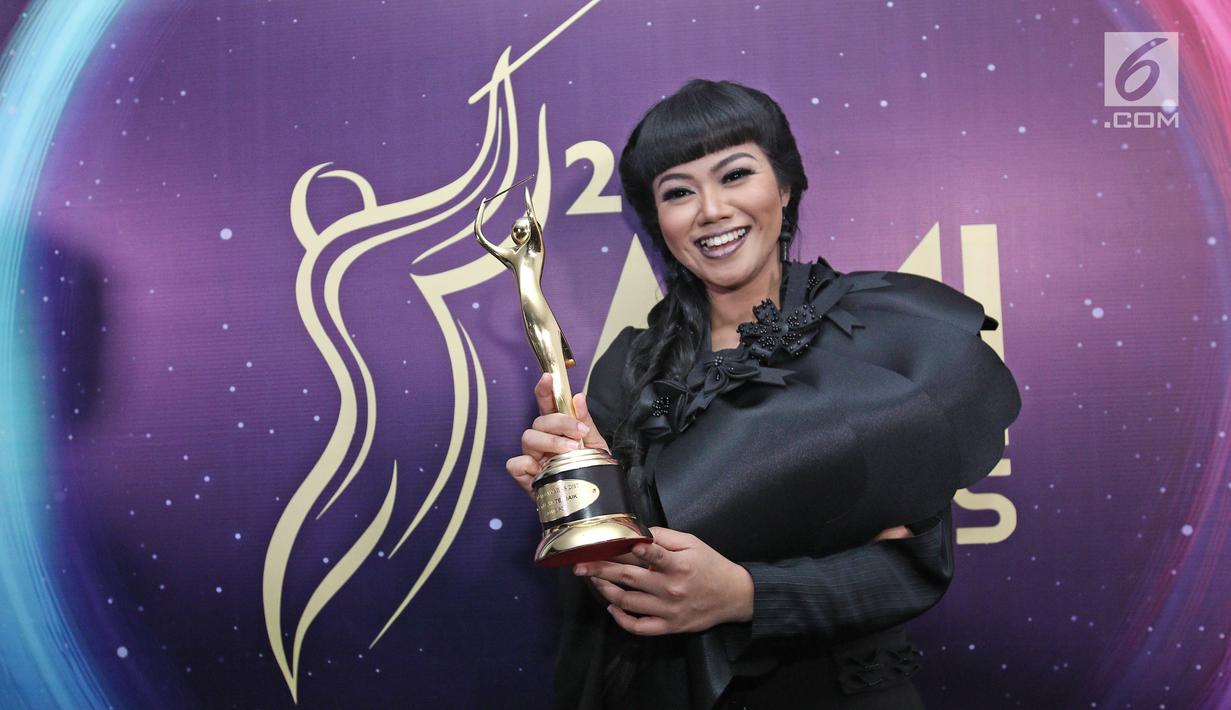 Penyanyi Yura berpose memenggang piala usai meraih penghargaan Anugerah Musik Indonesia (AMI) Awards 2017 di Teater Garuda TMII, Jakarta, Kamis (16/11). (Liputan6.com/Herman Zakharia)