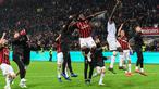 Gelandang AC Milan, Franck Kessie (tengah) dan rekan setimnya merayakan kemenangan bersama suporter usai pertandingan melawan Lazio pada lanjutan Liga Serie A Italia di stadion San Siro (13/4). Milan menang tipis 1-0 atas Lazio berkat gol penalti Kessie. (AFP Photo/Miguel Medina)
