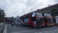 Penyedia bus dan stakeholder pariwisata di Kabupaten Pati menggelar konvoi sambil mengibarkan bendera putih, tanda menyerah dengan kebijakan PPKM. (Liputan6.com/ Ahmad Adirin)