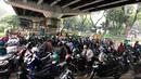 Pengendara sepeda motor berteduh di kolong flyover saat hujan mengguyur kawasan Tebet, Jakarta, Senin (14/9/2020). Kolong flyover kerap menjadi tempat berteduh bagi sebagian pengendara, meski kondisi tersebut dapat mengganggu arus lalu lintas. (Liputan6.com/Immanuel Antonius)