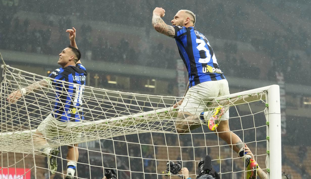 Pemain Inter Milan, Lautaro Martinez dan Federico Dimarco melakukan selebrasi dengan menaiki gawang saat perayaan juara setelah menaklukkan AC Milan di Stadion San Siro, Selasa (23/4/2024). Ini adalah trofi ke-20 Inter, La Beneamata berhak mengenakan dua bintang di atas logo klub di jersey mulai musim depan. (AP Photo/Luca Bruno)