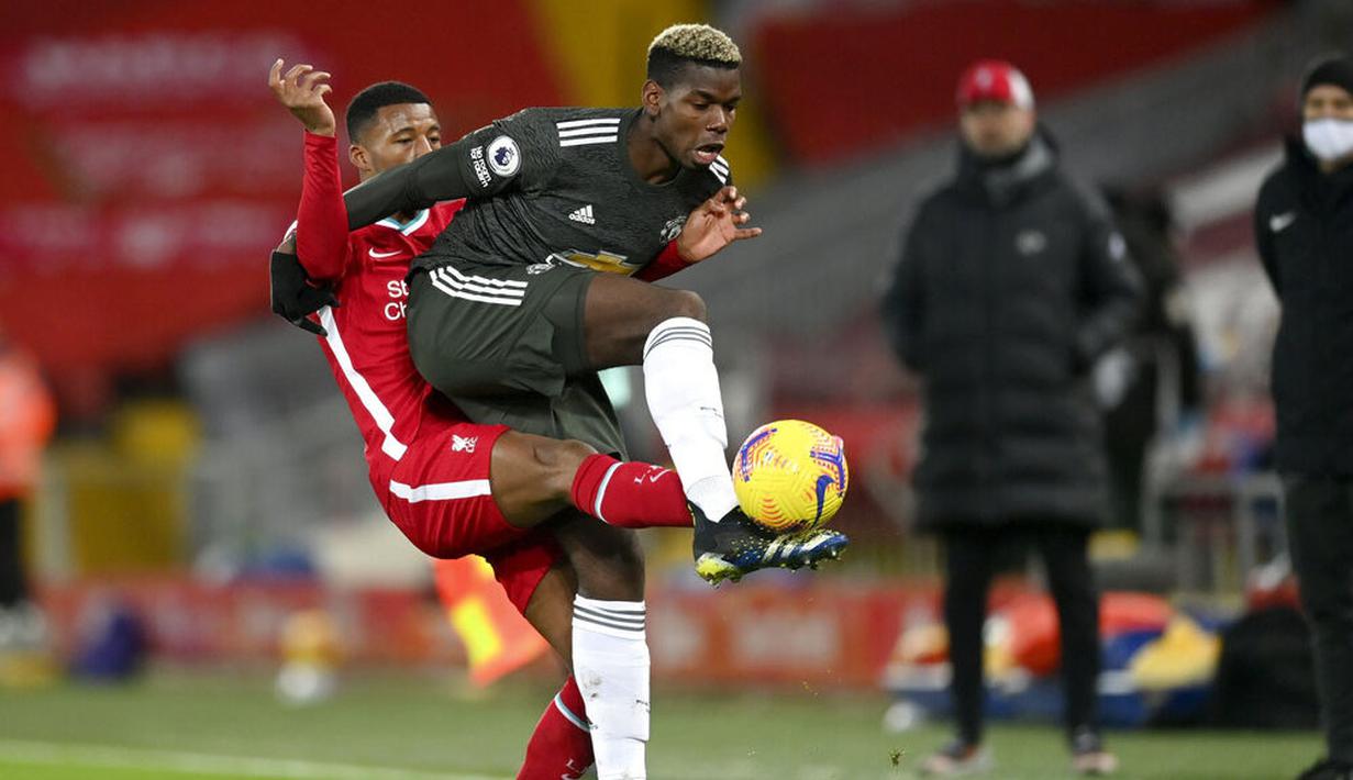 Pemain Manchester United, Paul Pogba, berebut bola dengan pemain Liverpool, Georginio Wijnaldum, pada laga Liga Inggris di Stadion Anfield, Minggu (17/1/2021). Kedua tim bermain imbang 0-0. (Michael Regan/Pool via AP)