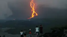 Warga melihat guguran lava pijar yang keluar dari gunung api Piton de la Fournaise atau Peak of the Furnace di Pulau Reunion, Samudera Hindia, Prancis, Selasa (13/8/2019). Letusan Piton de la Fournaise berlanjut hingga hari ketiga. (Richard BOUHET/AFP)