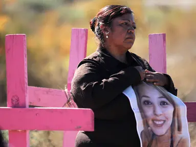Carmen Castillo memegang foto mendiang putrinya Monica Delgado di pemakaman Juarez, Negara Bagian Chihuahua, Meksiko, (24/11). Aksi tersebut digelar jelang Hari Penghapusan Kekerasan Perempuan Internasional.(AFP Photo/Herika Martinez)