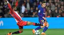 Aksi pemain Girona, Jonas Ramalho (kiri) menghalau bola sepakan pemain Barcelona, Philippe Coutinho pada La Liga Santander di Camp Nou stadium, Barcelona, (24/2/2018). Barcelona menang telak 6-1. (AFP/ Lluis Gene)