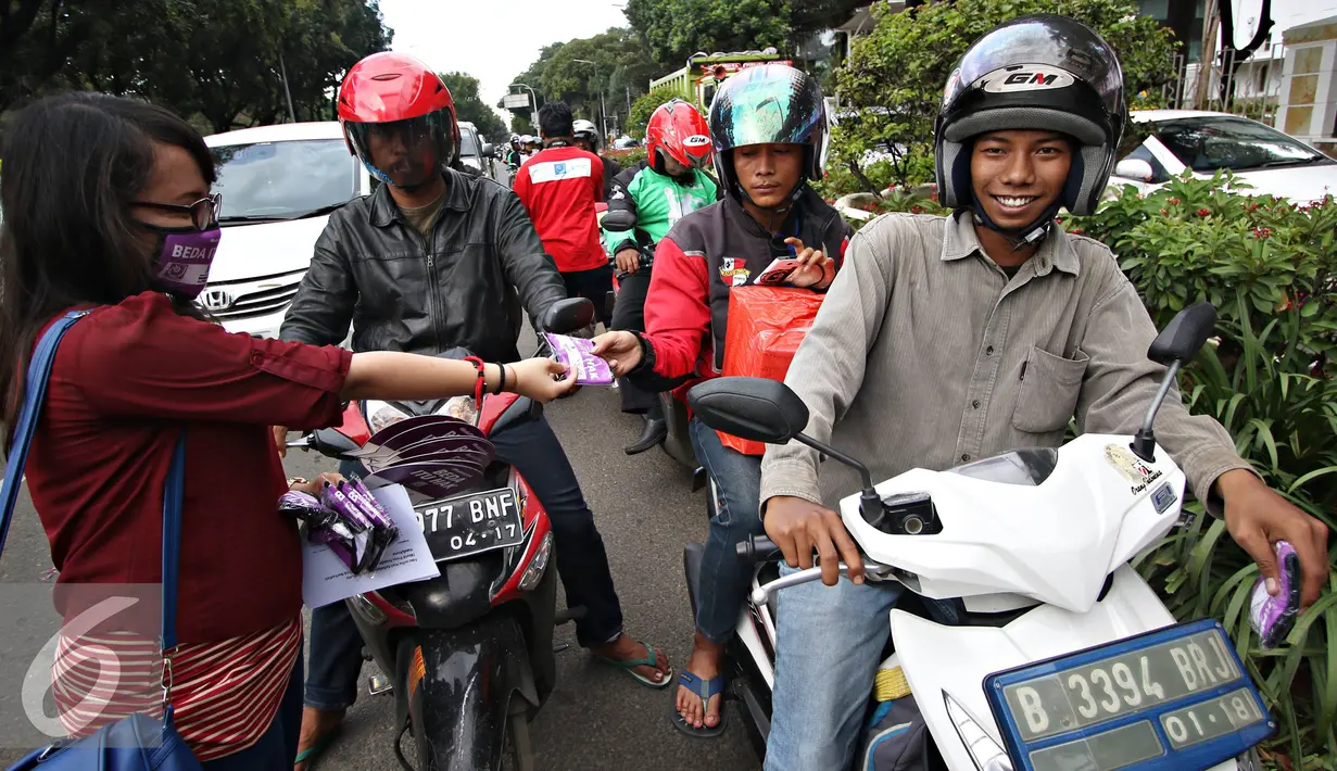 Massa Aliansi Jurnalis Independen melakukan aksi damai dengan membagikan masker dan kipas kepada pengendara di Jakarta, Selasa (3/5). AJI juga menyatakan bahwa musuh kebebasan pers 2016 adalah kepolisian. (Liputan6.com/Immanuel Antonius)