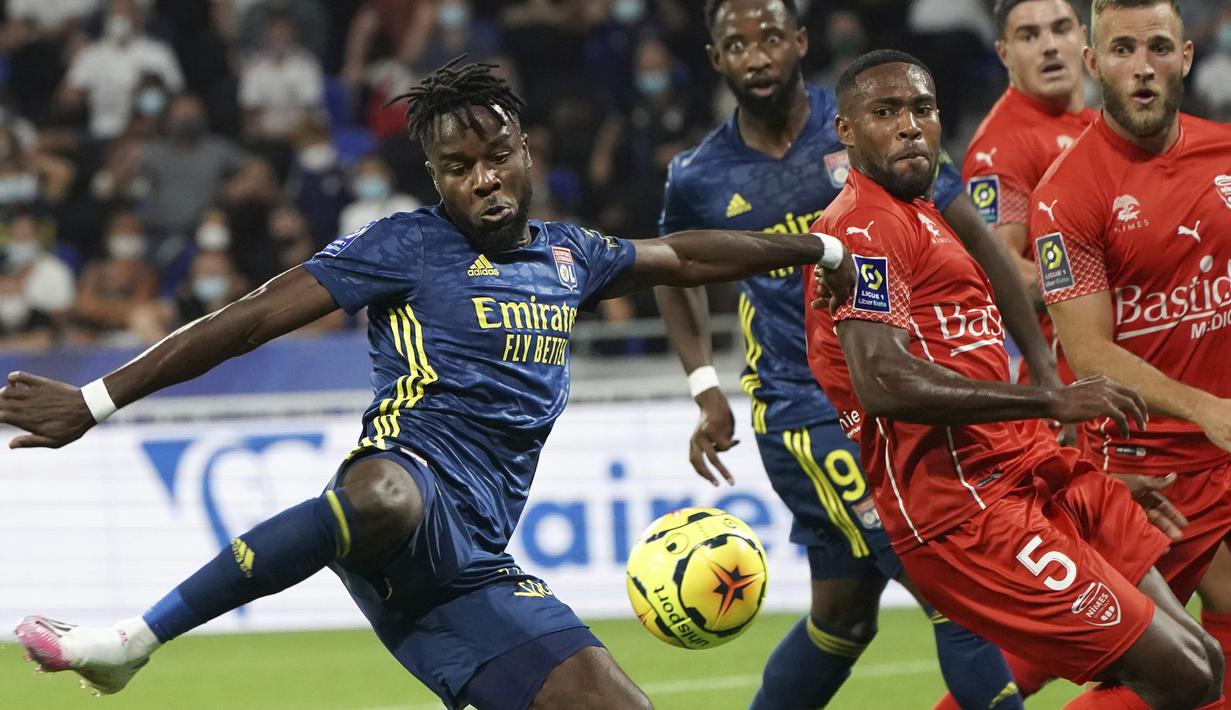 Penyerang Lyon, Maxwel Cornet, berusaha melepaskan tendangan saat menghadapi Nimes pada laga lanjutan Liga Prancis di Stadion Groupama, Sabtu (19/9/2020) dini hari WIB. Lyon bermain imbang 0-0 atas Nimes. (AP Photo/Laurent Cipriani)