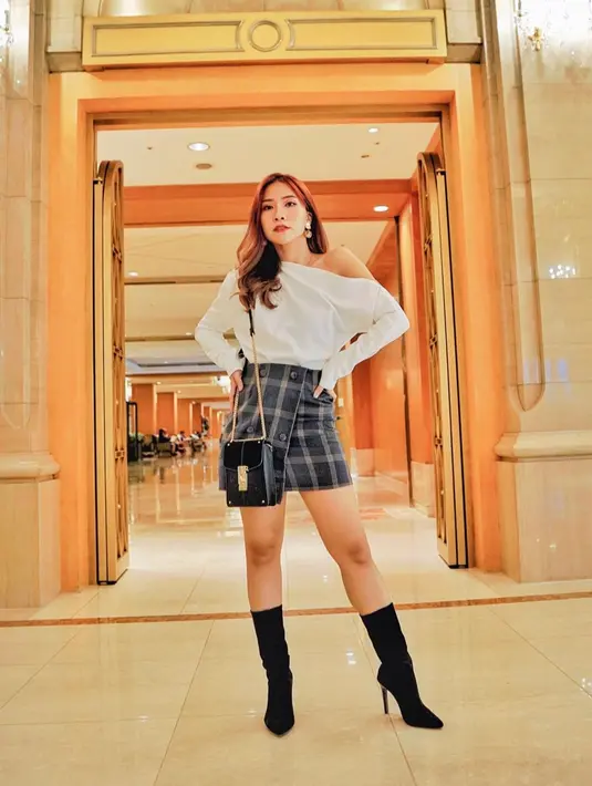 Tampil dengan look yang elegan, wanita yang dulunya berprofesi sebagai reporter ini mengenakan atasan putih yang dipadukan dengan rok bermotif kotak-kotak dan heels hitam. (Liputan6.com/IG/@natyashina)