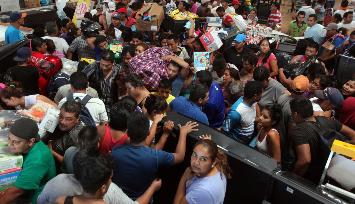 Warga berebut barang saat menjarah sebuah toko di pelabuhan Veracruz, Meksiko, (4/1). Akibat kejadian tersebut mengakibatkan kematian seorang polisi dan seorang saksi. (AP Photo / Felix Marquez)