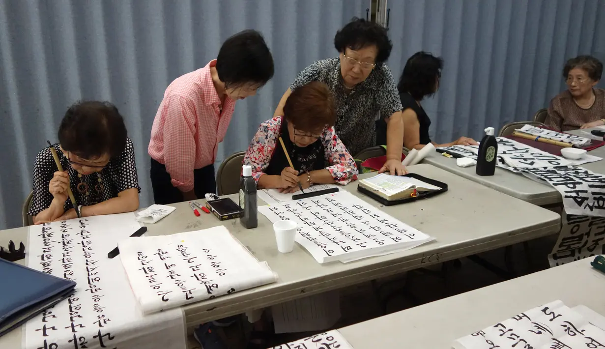 Wanita belajar membuat kaligrafi di pusat Layanan Komunitas Korea di New York, (10/8). Sekitar 1,7 juta keturunan Korea tinggal di AS-diaspora Korea terbesar kedua di dunia setelah China. (AFP Photo/Don Emmert)
