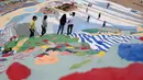 Turis mengunjungi Salvation Mountain, sebuah lereng bukti di Niland, California, Amerika Serikat. Salvation Mountain memiliki lebar 46 meter, dan panjang 15,2 meter ini tidak dihiasi pepohonan, melainkan tulisan dan gambar warna-warni dengan pesan cinta. (Robyn Beck/AFP)