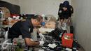 Petugas labfor Polda Metro melakukan pengujian bahan yang diduga digunakan untuk membuat sabu, Jakarta (25/7). Kepolisian Polda Metro Jaya menggerebek sebuah gudang yang diduga pabrik narkoba jenis sabu di kawasan Penjaringan. (Liputan6.com/Yoppy Renato)