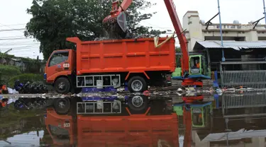 Petugas mengangkut sampah yang terbawa arus sungai Ciliwung ke dalam truk, Jakarta, Selasa (23/10). Dinas Lingkungan Hidup mengantisipasi terjadinya peningkatan volume sampah saat musim penghujan tiba di setiap pintu air Jakarta. (Merdeka.com/Imam Buhori)