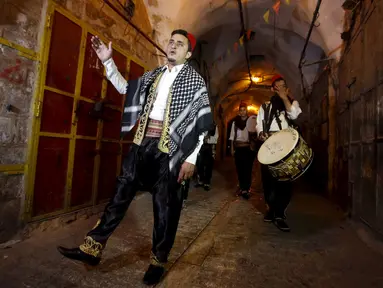 Sejumlah pemuda Palestina memainkan musik tradisional saat membangunkan sahur di permukiman Hebron, Tepi Barat, 23 Juni 2015. Tradisi tersebut dilakukan secara turun-temurun untuk mempererat silaturahmi. (REUTERS/Mussa Qawasma)