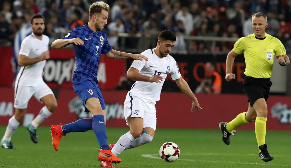 Pemain Kroasia, Ivan Rakitic berusaha merebut bola dari pemain Yunani, Sokratis Papastathopoulos pada laga leg kedua play-off Piala Dunia 2018 di Stadion Karaiskakis, Senin (13/11). Kroasia menang dengan agregat 4-1 atas Yunani. (AP/Yorgos Karahalis)