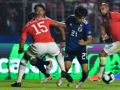 Gelandang Jepang, Takefusa Kubo (tengah) berusaha melewati dua pemain Chile, Jean Beausejour dan Arturo Vidal selama pertandingan grup C Copa America 2019 di Stadion Morumbi, Sao Paulo, Brasil (17/6/2019). Kubo merupakan remaja 18 tahun yang dijuluki 'Messi Jepang'. (AFP Photo/Nelson Almeida)