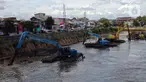 Ekskavator mengeruk endapan material lumpur pada aliran Kali Ciliwung di Jakarta, Selasa (16/1/2023). Proyek ini dilakukan untuk mengurangi pendangkalan kali dan bagian dari program pencegahan penanggulangan banjir yang sudah masuk musim penghujan. (merdeka.com/Imam Buhori)