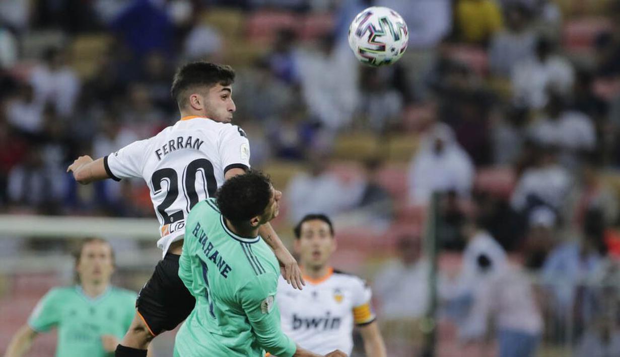 Bek Real Madrid, Varane, berebut bola dengan pemain Valencia, Ferran Torres, pada laga Piala Super Spanyol di Stadion King Abdullah Sport City, Arab Saudi, Rabu (8/1/2020). Real Madrid menang 3-1 atas Valencia. (AP/Amr Nabil)